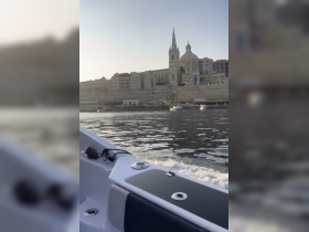 A scenic view of a coastal city from a boat, showcasing beautiful architecture and tranquil waters — perfect for exploring urban waterfronts.