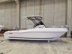 A sleek speedboat displayed in a warehouse, showcasing its modern design and features — perfect for water enthusiasts looking for adventure.