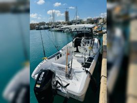 A sleek speedboat named 'Hooked Malta' is docked in a vibrant marina, showcasing its fishing gear and modern design — perfect for fishing trips or leisure outings in Valletta.