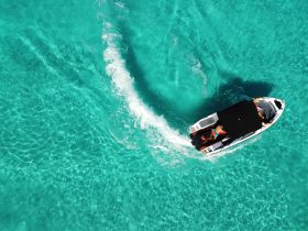 A thrilling view of a boat cruising through stunning turquoise waters, showcasing the excitement of on-water adventures.