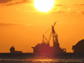 A stunning silhouette of cargo ships against a vibrant sunset, capturing the essence of maritime beauty and tranquility.