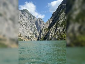 Breathtaking view of towering mountains surrounding tranquil waters, perfect for nature lovers and scenic boat tours.