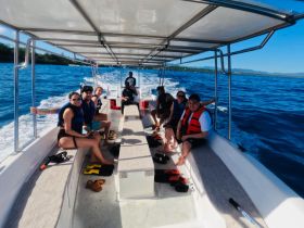 A lively group enjoys a boat ride, equipped with life jackets and ready for snorkeling adventures — perfect for exploring vibrant marine life.
