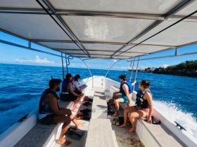 A group of friends enjoys a boat ride, taking in the beautiful ocean views while wearing life jackets. Perfect for adventure seekers looking to explore the waters.