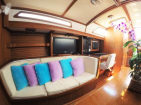 Cozy interior of a boat cabin featuring plush seating and a modern entertainment setup, perfect for relaxing during voyages.