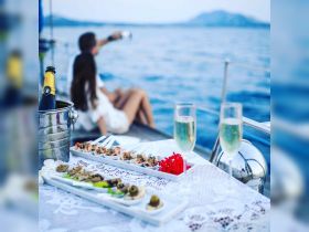 A beautifully arranged dining setup featuring gourmet dishes and champagne on a yacht, perfect for romantic outings or special celebrations at sea.