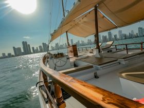 A stunning view of a yacht sailing with a city skyline in the background, showcasing the elegance of boating in urban waters.