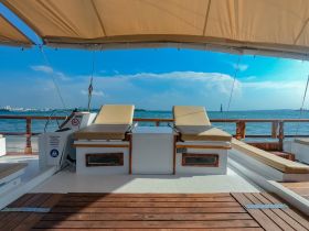 A serene view of the helm and seating area inside a boat, showcasing the spacious and comfortable interior designed for relaxation on the water.