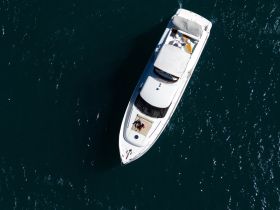 Aerial view of a couple relaxing on the deck of a luxurious yacht, showcasing a perfect day on the water.