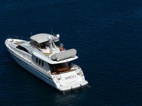 A luxurious yacht named 'Morena I' cruising through deep blue waters, with guests enjoying the sun on deck — perfect for upscale boating experiences.