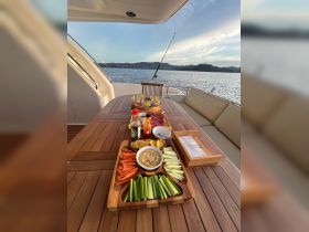 A beautifully arranged platter of snacks and drinks on a yacht's dining table, perfect for enjoying while cruising the scenic waters.