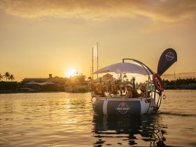 A lively group enjoys a sunset cruise aboard a BBQ boat, creating unforgettable memories on the water with friends.