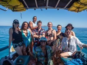 A cheerful group of friends poses together on a boat, enjoying their time on the water — perfect for memorable adventures and celebrations.