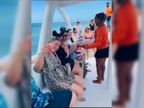 A lively group enjoys drinks on a boat, celebrating together in a vibrant atmosphere — perfect for memorable outings on the water.