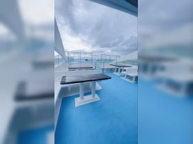Interior view of a spacious boat deck featuring seating areas, perfect for relaxing while enjoying the ocean views.