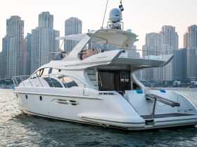 A stunning side view of a luxurious yacht docked against a backdrop of modern skyscrapers, showcasing its elegant design and spacious layout.