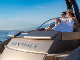 A couple enjoys a relaxing moment on the deck of the yacht 'Divina', soaking up the sun and the beautiful ocean views — perfect for romantic getaways.