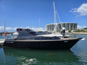 A sleek black yacht named 'Revelation' docked at a marina, showcasing its modern design against a clear blue sky.