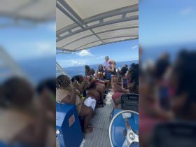 A lively group enjoys cocktails aboard a boat, celebrating together under the sun — perfect for memorable outings and party experiences on the water.