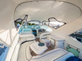 A spacious and elegantly designed interior of a boat, featuring comfortable seating and a well-equipped helm, perfect for relaxing and navigating on the water.