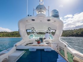 A spacious helm area on a luxury yacht, featuring comfortable seating and a scenic view of the coastline — perfect for relaxing while cruising.