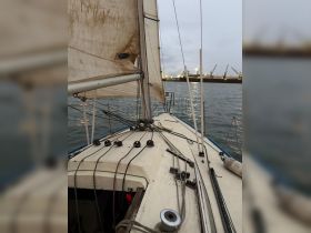 A close-up view of the helm area on a sailboat, showcasing the rigging and controls, perfect for sailing enthusiasts.