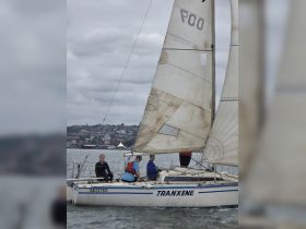 A group of friends enjoys a sailing adventure on the boat 'Tranxene,' capturing the essence of outdoor fun and camaraderie on the water.