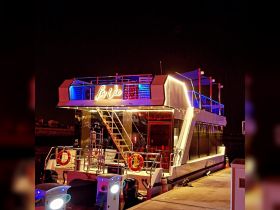A beautifully illuminated yacht named 'La Vie' docked at night, showcasing its stunning design and vibrant lighting — perfect for evening cruises and events.