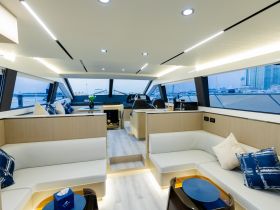 A stylish interior view of a modern yacht cabin, featuring comfortable seating and a well-equipped helm, perfect for relaxing or navigating the waters.
