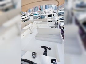 A sleek interior view of a boat's helm and seating area, showcasing modern design and comfort for an enjoyable boating experience.
