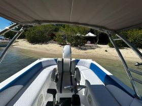 Interior view of a sleek boat showcasing comfortable seating and a well-equipped helm, perfect for a day out on the water.