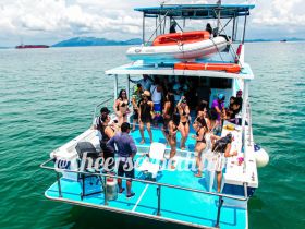 A lively group enjoys a fun day on a boat, celebrating with drinks and music under the sun — perfect for summer parties and gatherings on the water.