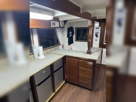 Interior view of a boat's cabin featuring a well-equipped kitchen area with storage and appliances, ideal for onboard dining and relaxation.