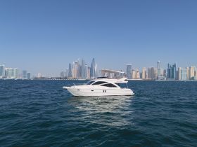 A stunning yacht cruising through the waters with a backdrop of a vibrant city skyline, perfect for luxury boating experiences.