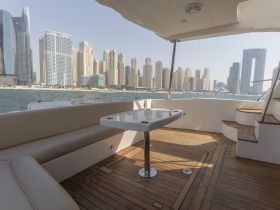 A stylish interior view of a boat's dining area, showcasing comfortable seating and a sleek design, perfect for enjoying meals while cruising along the waterfront.