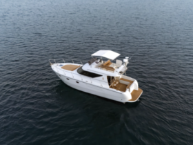 Aerial view of a sleek yacht cruising through calm waters, showcasing its elegant design and spacious deck — perfect for luxury outings or private charters.