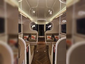 A sleek and modern interior of a boat cabin featuring comfortable seating and elegant design, perfect for relaxing during a day on the water.