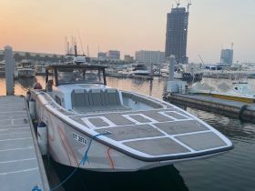 A sleek speedboat docked at the marina, showcasing its modern design against a serene sunset backdrop — perfect for thrilling water adventures.