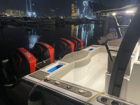 A well-equipped boat interior featuring a sleek helm and console, perfect for nighttime adventures at the marina.