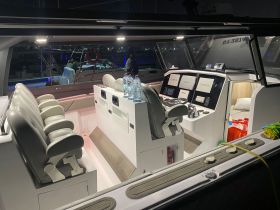 An interior view of a modern boat helm featuring comfortable seating and advanced navigation equipment, perfect for a smooth sailing experience.