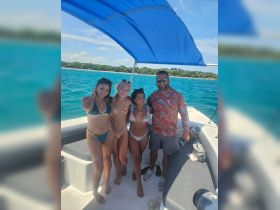 A cheerful group of friends poses together on a boat, enjoying a sunny day on the water — perfect for memorable outings and celebrations.