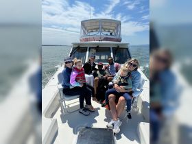 A joyful family gathers on the deck of a boat, enjoying a sunny day on the water — perfect for creating lasting memories together.