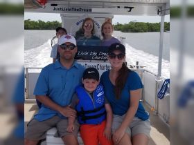 A joyful family poses together on a charter boat, capturing a memorable moment during their aquatic adventure. Perfect for showcasing family-friendly boating experiences.