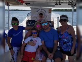 A cheerful family enjoys a sunny day on the boat, creating lasting memories together on the water.