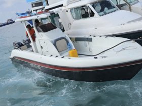 A sleek speedboat is docked, showcasing its design and features, with crew members visible preparing for the next adventure.