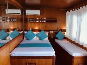 Cozy cabin interior featuring a comfortable bed and seating area, perfect for relaxing during your boating adventures.