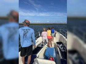 A family enjoys a day on the water, exploring the scenery from their boat — a perfect outing for adventure and bonding.