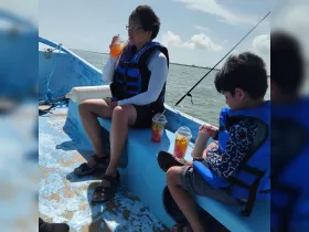 A family enjoys refreshing drinks while relaxing on a boat, showcasing a perfect day out on the water.