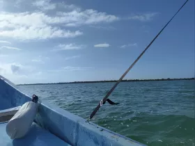 A serene view of a boat's bow cutting through calm waters under a clear blue sky, perfect for showcasing the beauty of a day on the water.