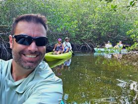 A group enjoys a kayaking adventure through lush mangroves, capturing the essence of outdoor exploration and camaraderie.